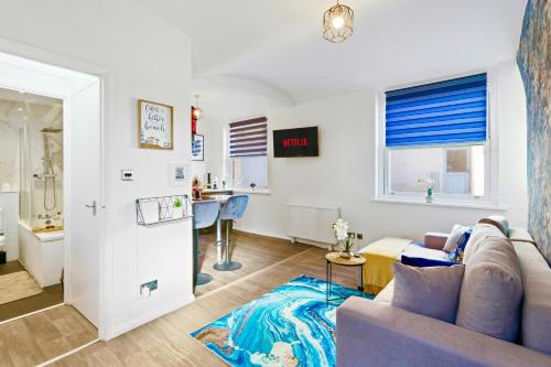 ein Wohnzimmer mit Sofa und Tisch in der Unterkunft Modern 1-Bed Serviced Apartment - Central Brighton in Brighton & Hove