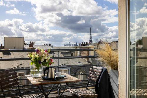 a table on a balcony with a view of a city at Hôtel De Castiglione in Paris