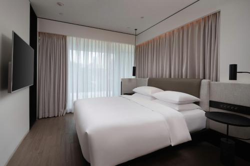 a bedroom with a large white bed and a television at Mumian Shenzhen Luohu JDV by Hyatt in Shenzhen