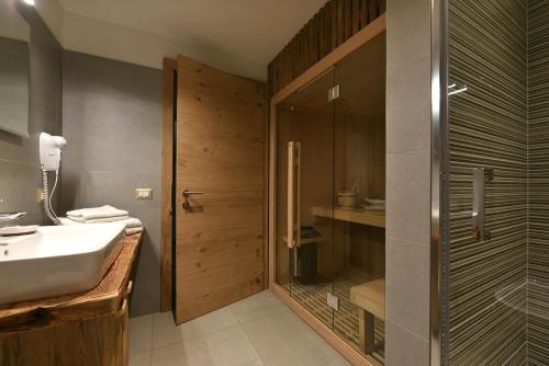 a bathroom with a sink and a glass shower at Agriturismo Soleseid in San Vigilio Di Marebbe