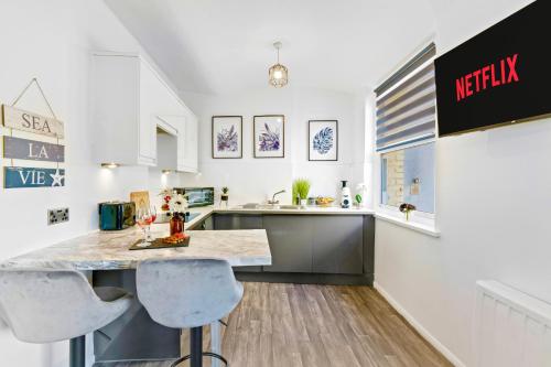 a kitchen with a counter and two bar stools at Modern 1-Bed Serviced Apartment - Central Brighton in Brighton & Hove