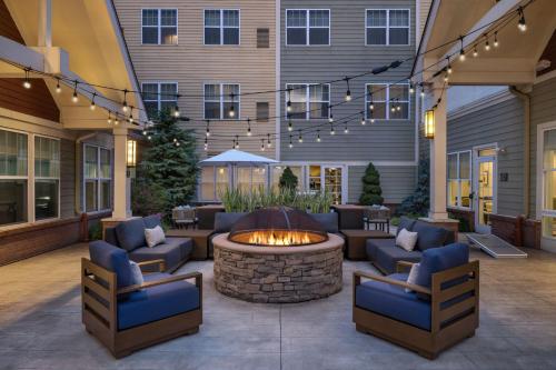 a patio with a fire pit and chairs and a building at Residence Inn by Marriott Long Island Islip/Courthouse Complex in Central Islip