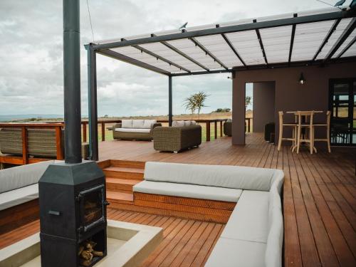 a deck with a stove and couches on a house at Longhill Reserve in Addo
