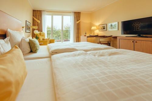 a hotel room with two beds and a window at GRAND ELYSEE Hamburg in Hamburg