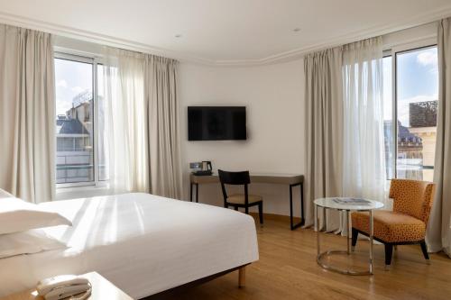 a hotel room with a bed and a table and chairs at Hôtel De Castiglione in Paris