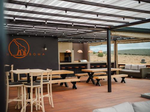 a restaurant with wooden tables and chairs and a couch at Longhill Reserve in Addo