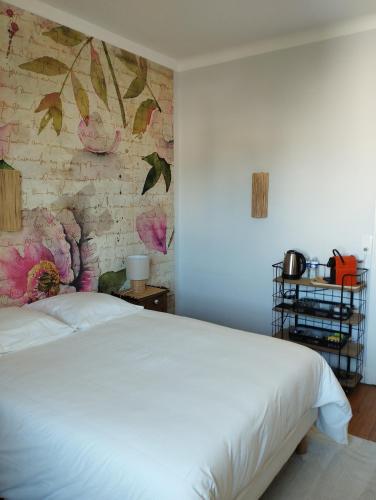 une chambre avec un lit blanc et un mur de briques dans l'établissement Villa Saint-Germain, à Saint-Georges-de-Didonne