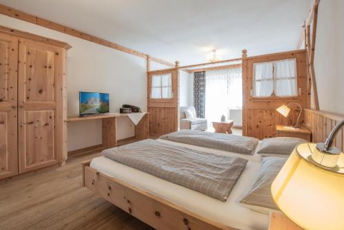 two beds in a bedroom with wooden walls at Agriturismo Soleseid in San Vigilio Di Marebbe