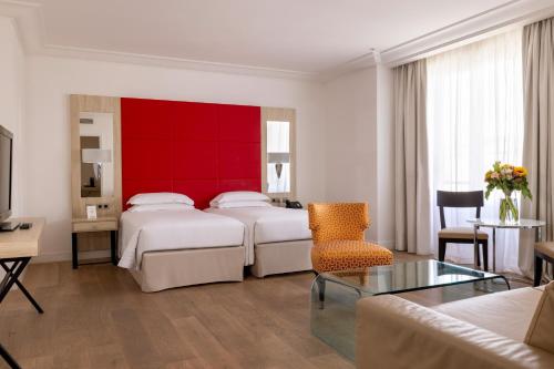 a hotel room with two beds and a red wall at Hôtel De Castiglione in Paris
