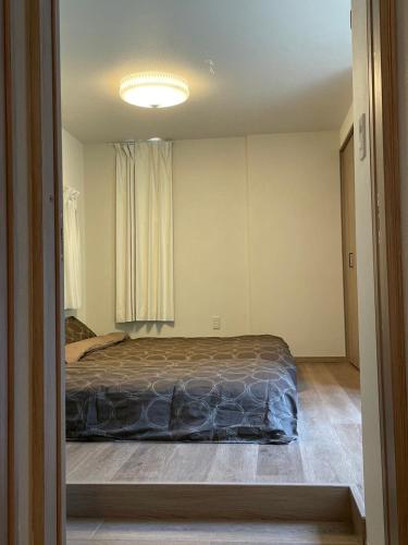 a bedroom with a bed and a large window at 森ステイ第二 in Ome