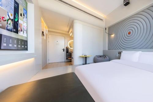 a hotel room with a white bed and a hallway at Atour X Hotel Beijing Wangjing 798 in Beijing