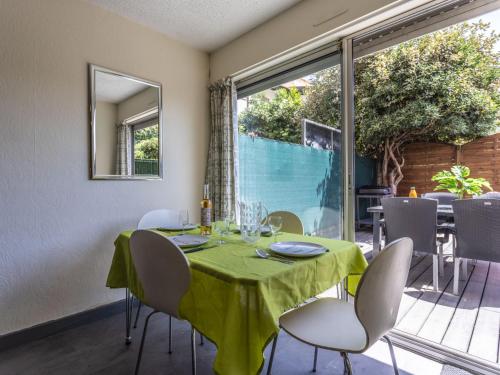 une salle à manger avec une table et des chaises vertes dans l'établissement Apartment Les Grenadines-2 by Interhome, au Cap d'Agde
