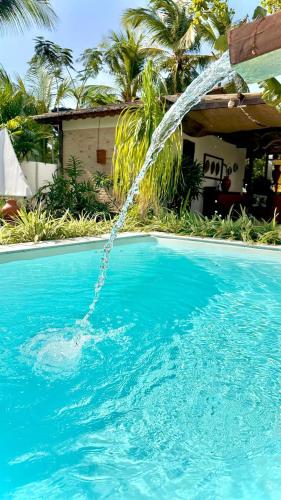 a pool with a stream of water pouring into it at Villa Biju in Jericoacoara