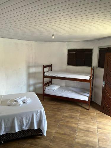 a room with two beds and a wooden floor at Destino Hospeda in Pipa