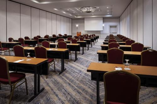 a conference room with tables and chairs and a screen at Bakersfield Marriott at the Convention Center in Bakersfield