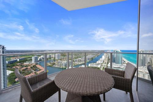 a table and chairs on a balcony with a view of the ocean at Beautiful Beachfront Penthouse in Hollywood