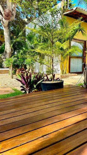 a wooden deck in front of a house with trees at Villa Biju in Jericoacoara