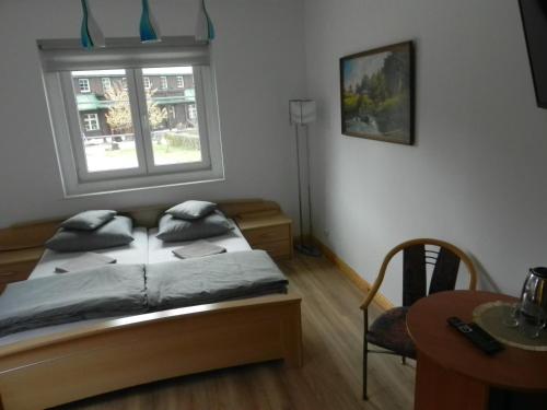 a bedroom with a bed and a window and a table at Osada Chybotek in Przesieka