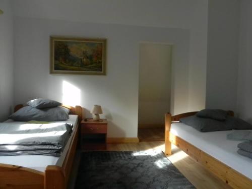 a bedroom with two beds and a picture on the wall at Osada Chybotek in Przesieka