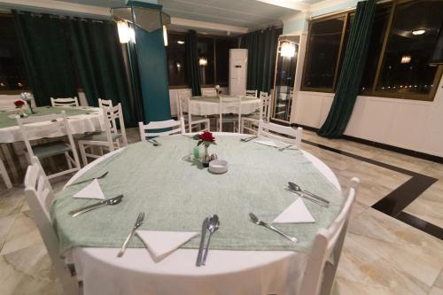 a dining room with a table with a green table cloth at Red Sea Hotel in Būr Tawfīq