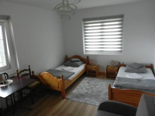 a bedroom with two beds and a table and window at Osada Chybotek in Przesieka