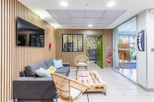 un salon avec un canapé et une table dans l'établissement Appart'City Confort Saint-Nazaire Océan, à Saint-Nazaire