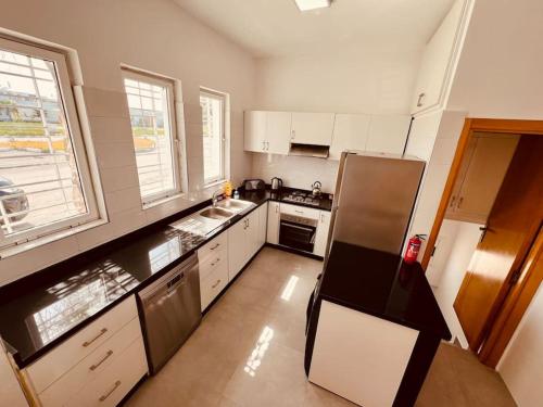 eine kleine Küche mit weißen Schränken und Geräten in der Unterkunft Villa Petit Val d'Or - 3BR Comfort, and Beachside in Temara