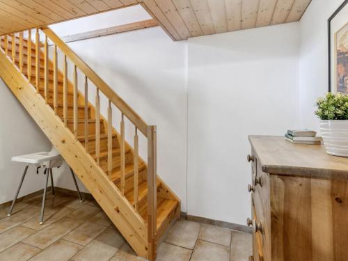 a wooden staircase in a room with a table at Apartment Racer's Retreat Apt-07 by Interhome in Wengen