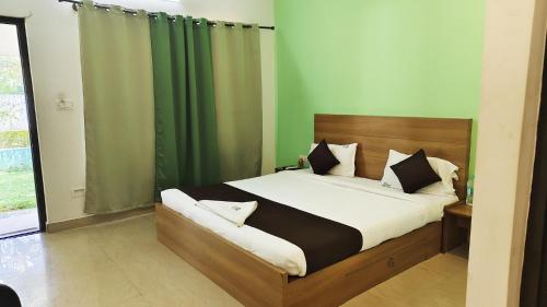 a bedroom with a bed with a green curtain at Rithu Beach Villa in Alleppey