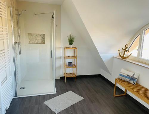 a bathroom with a shower with a glass door at Reetdach-Ferienhaus "ANNI" mit direktem Meerblick, Sauna und Kamin in Pepelow