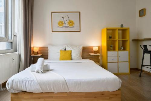 - une chambre avec un grand lit et un vélo sur le mur dans l'établissement Lille gares studio avec parking sécurisé, à Lille