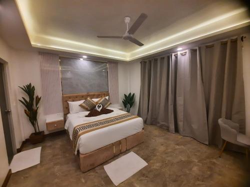 a bedroom with a bed and a ceiling fan at Whales Lodge in Maamigili