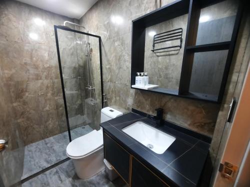 a bathroom with a toilet and a sink and a shower at Whales Lodge in Maamigili