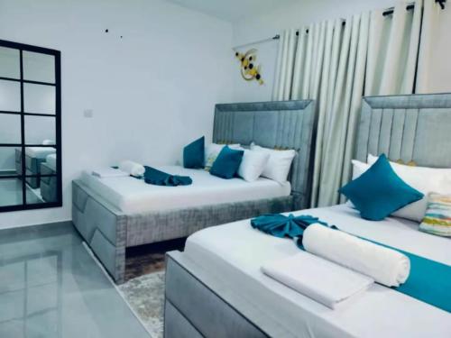two beds in a room with blue and white at Fully furnished apartment in Nyali near the beach in Mombasa