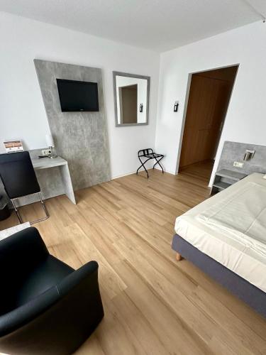 a bedroom with a bed and a couch and a television at Asgard Hotel in Worms