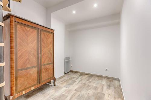 Cette chambre est dotée d'une grande porte en bois sur un mur. dans l'établissement République Canal St Martin Charming Apartment, à Paris