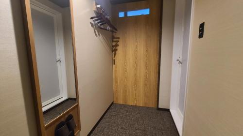 a hallway with a door and a mirror in a room at 今治ステーションホテル in Imabari