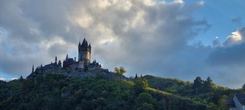 a castle sitting on top of a hill at Pension Regina in Cochem