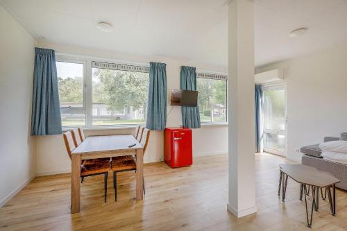 a living room with a table and a red refrigerator at Landgoed Leudal in Haelen