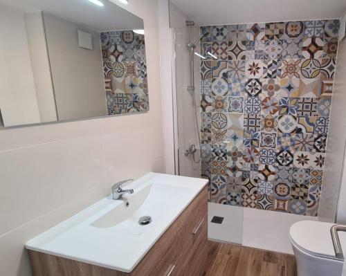 a bathroom with a sink and a mirror and a shower at CT 344 AL - Faro's Teckel Apartments Geminis Sky in Aguadulce
