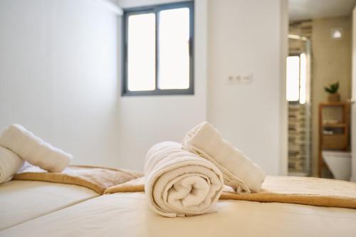 una pila di asciugamani appoggiata sopra un letto di Villa Carmen Albir a Albir