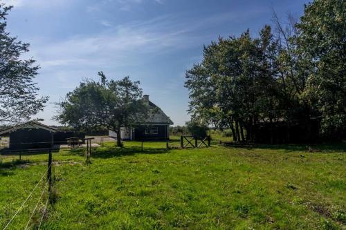 a house in a field with trees and a fence at Villa Soldal in Sindal