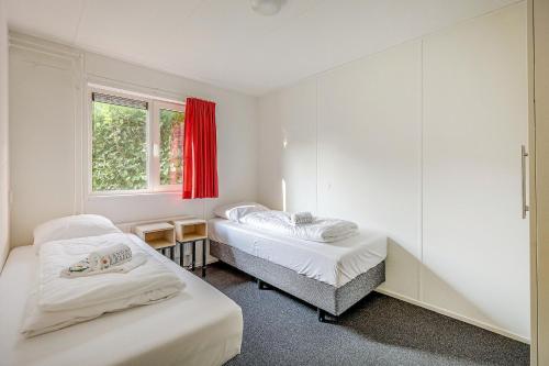 two beds in a room with a window at Landgoed Leudal in Haelen