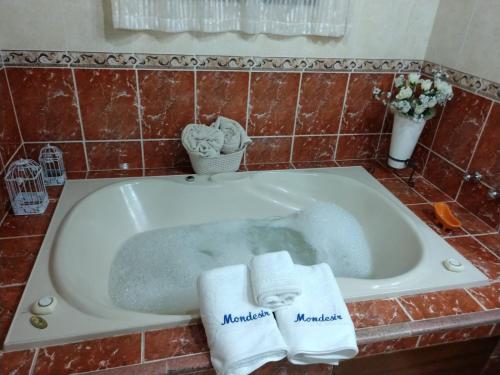 a bath tub with two towels sitting in it at Pousada Mon Desir in Penedo