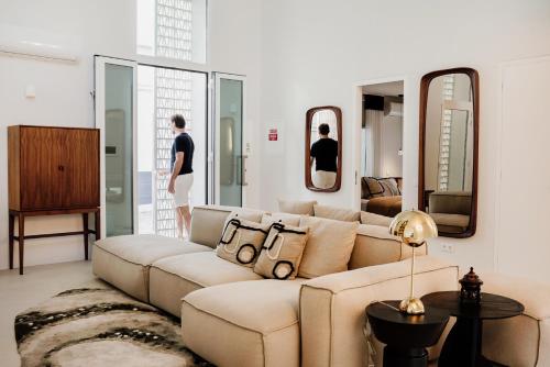 a living room with a large couch and mirrors at Casa da Fé in Lagoa