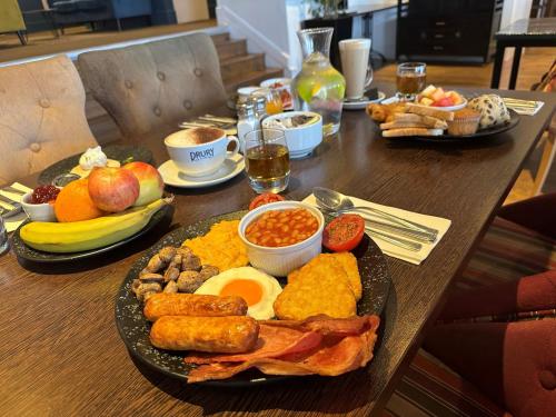 a wooden table with a plate of breakfast food at Queens Hotel & Spa in Brighton & Hove