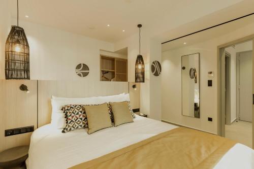 a bedroom with a large white bed with pillows at Opal Paros in Naousa