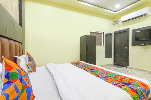 a bedroom with a bed and a tv on the wall at FabExpress GS Residency in Varanasi