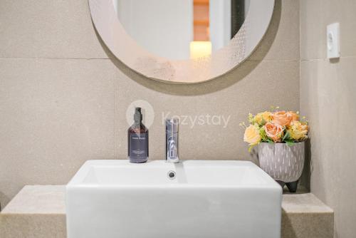 a bathroom sink with a bottle of wine on it at Bialy by Kozystay - Alam Sutera in Tangerang