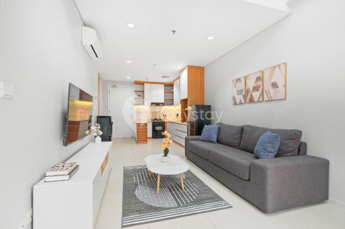 a living room with a couch and a table at Bialy by Kozystay - Alam Sutera in Tangerang
